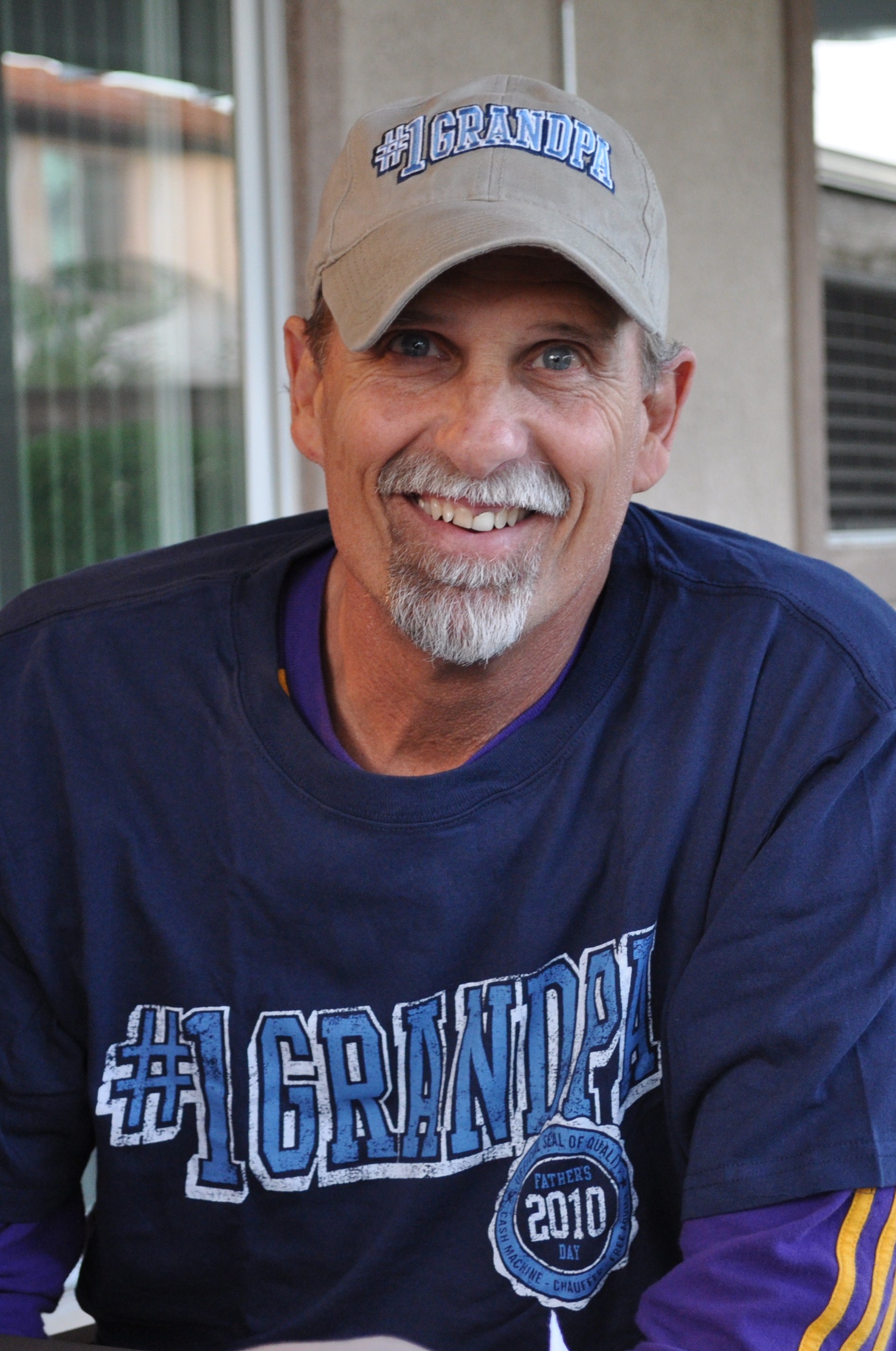 Randy smiling in his number one Grandpa hat and shirt later in life