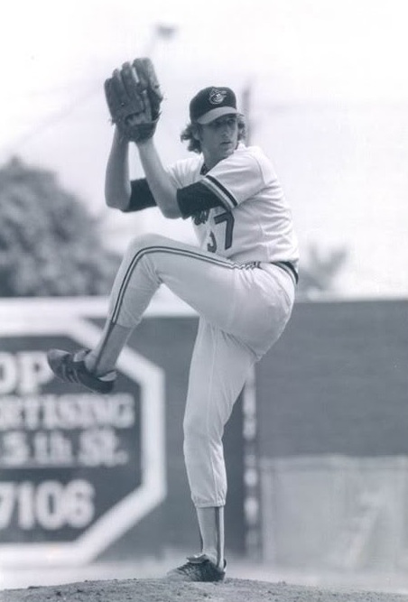 Black-and-white photograph of Randy with his leg raised during his pitching windup